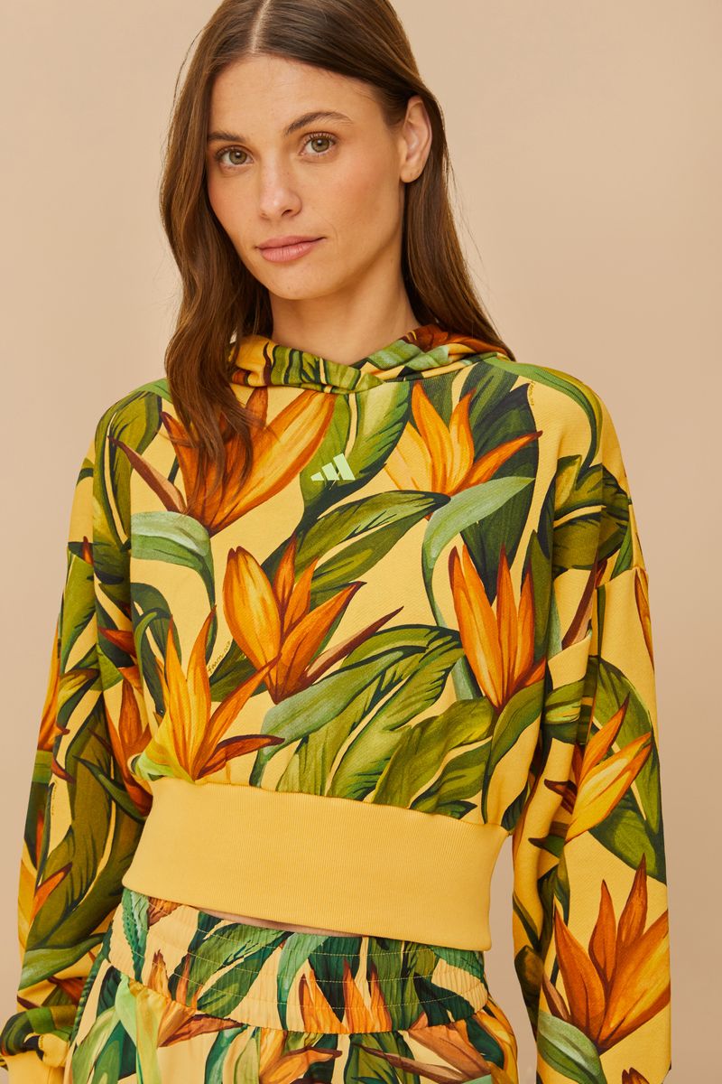 Close-up de la capucha de la chaqueta cortada Adidas Bird of Paradise con estampado tropical.