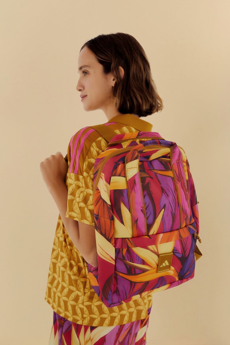 Mochila Adidas Bird Of Paradise Morada con diseño tropical vibrante en tonos morado, naranja y amarillo, vista lateral.