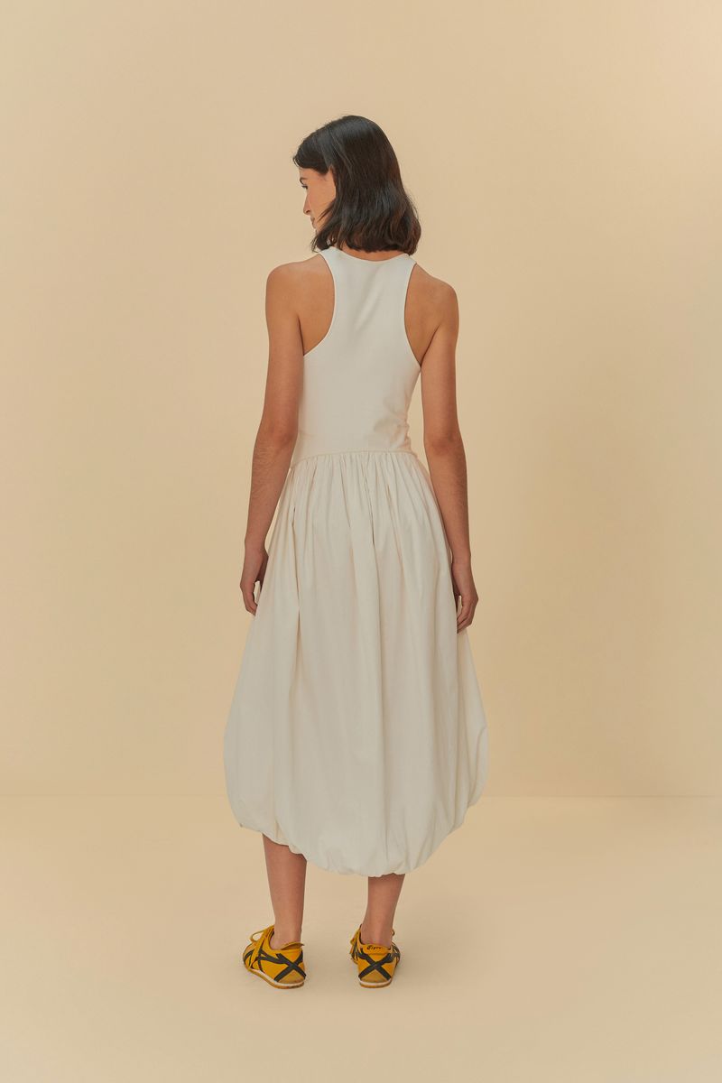 La modelo sostiene una bolsa estampada mientras lleva el vestido blanco con bordado de tigre.