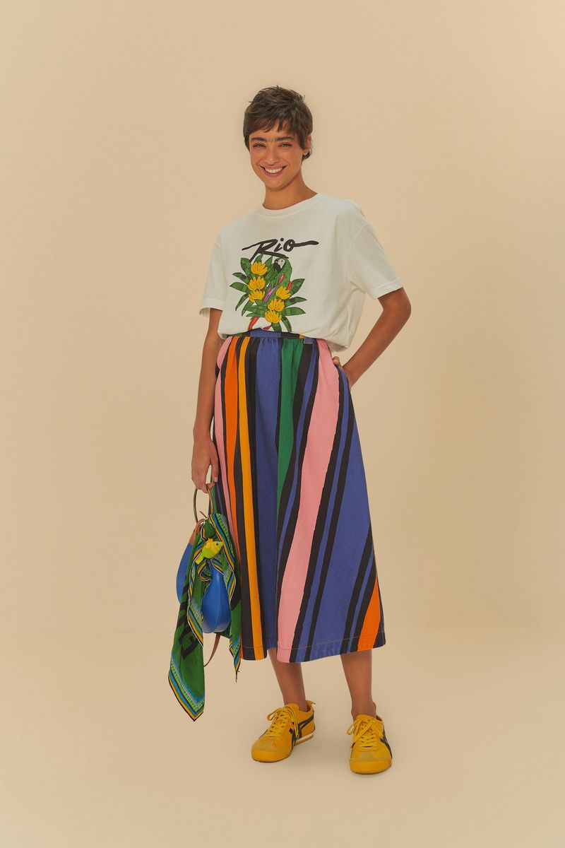 Modelo usando camiseta con estampado tropical combinada con falda a rayas.