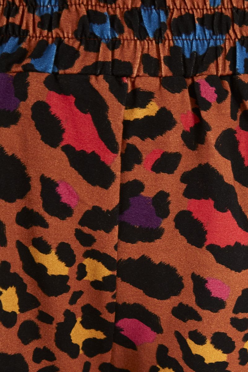 Imagen de una modelo luciendo el short Clochard Onça Rainbow con una blusa a juego, vista de espalda.