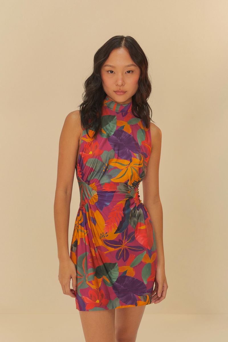 Vestido corto con estampado floral tropical, visto desde el frente, destacando el ajuste en la cintura y el escote alto.