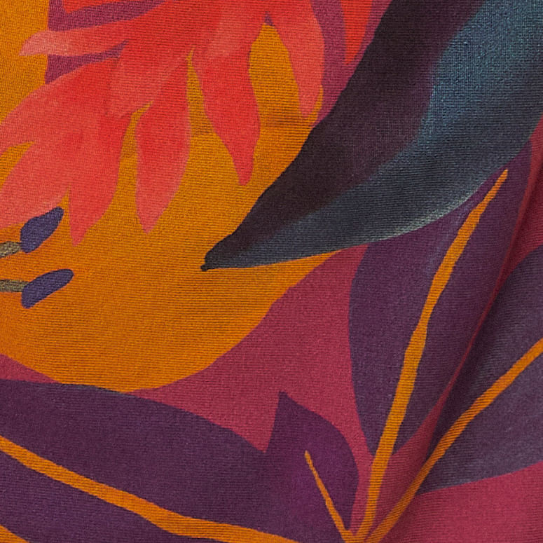 Acercamiento a la tela del vestido corto con estampado floral tropical, destacando los detalles del diseño floral.