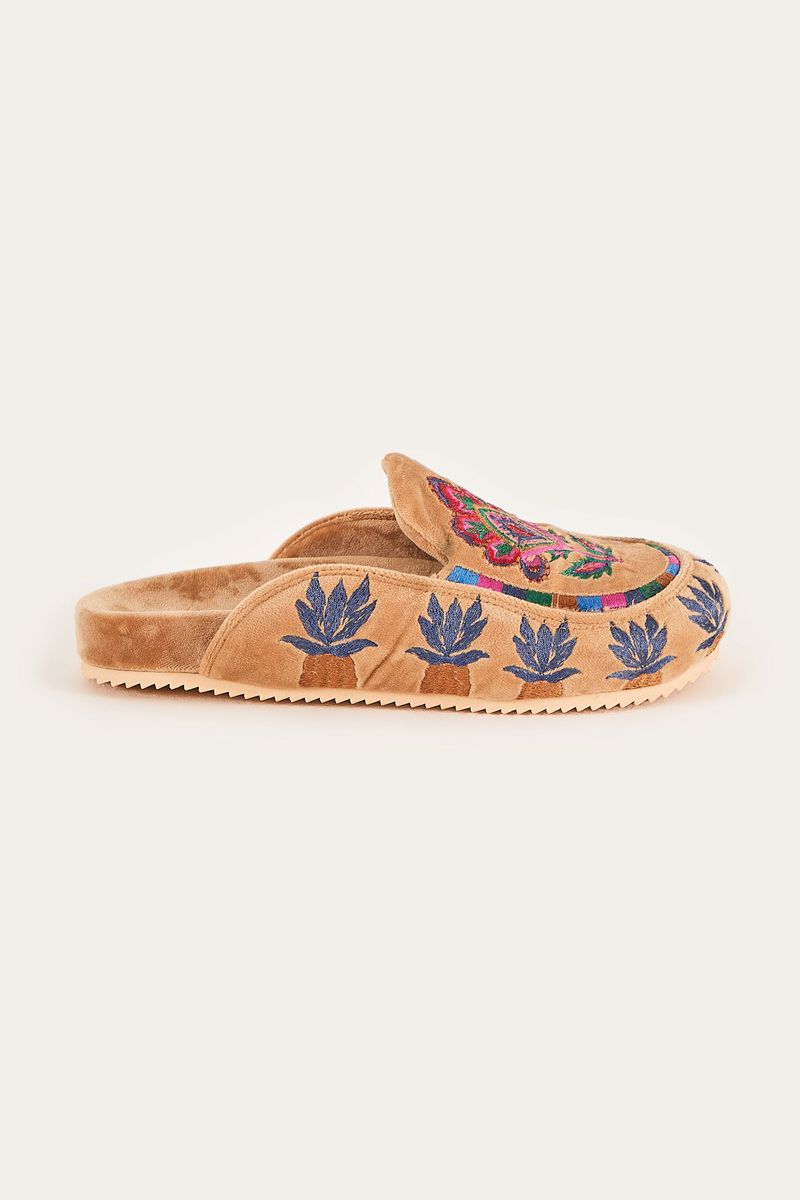Mocasines estilo clog en terciopelo camel con bordados de tapicería vistos desde el perfil.