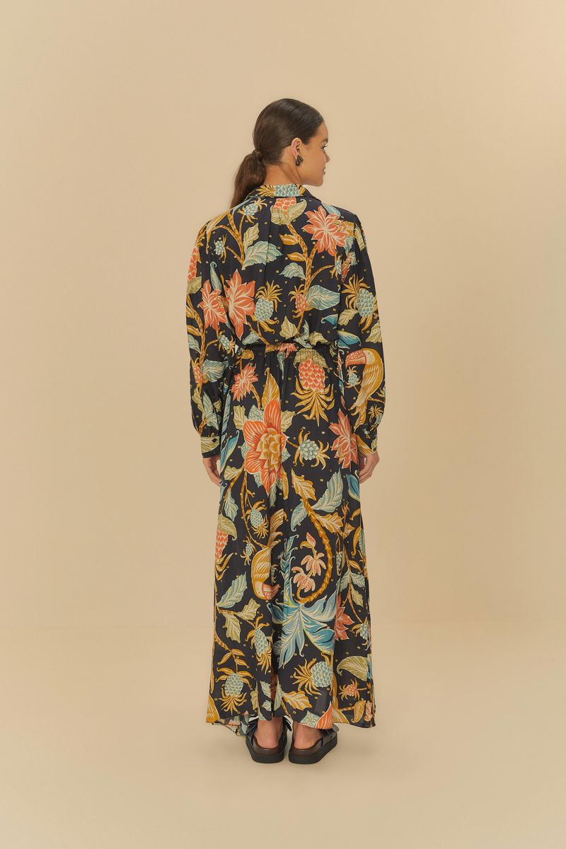 Vista trasera del vestido estampado con patrón floral y botánico, mostrando el patrón completo y el largo hasta los pies.