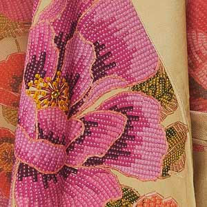 Detalle del chaleco beige con estampado floral vibrante, mostrando el diseño lateral.