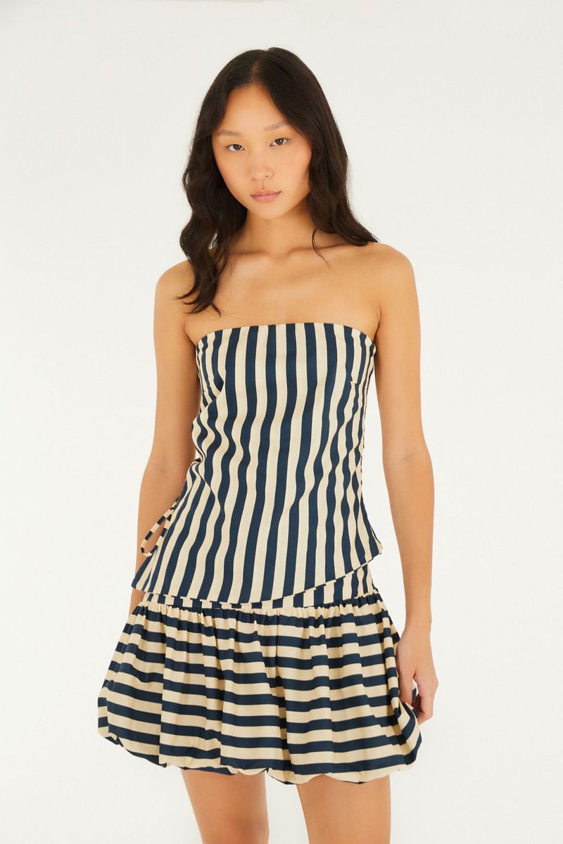 Modelo vistiendo la falda Balone Listra con estampado de rayas en azul y beige.