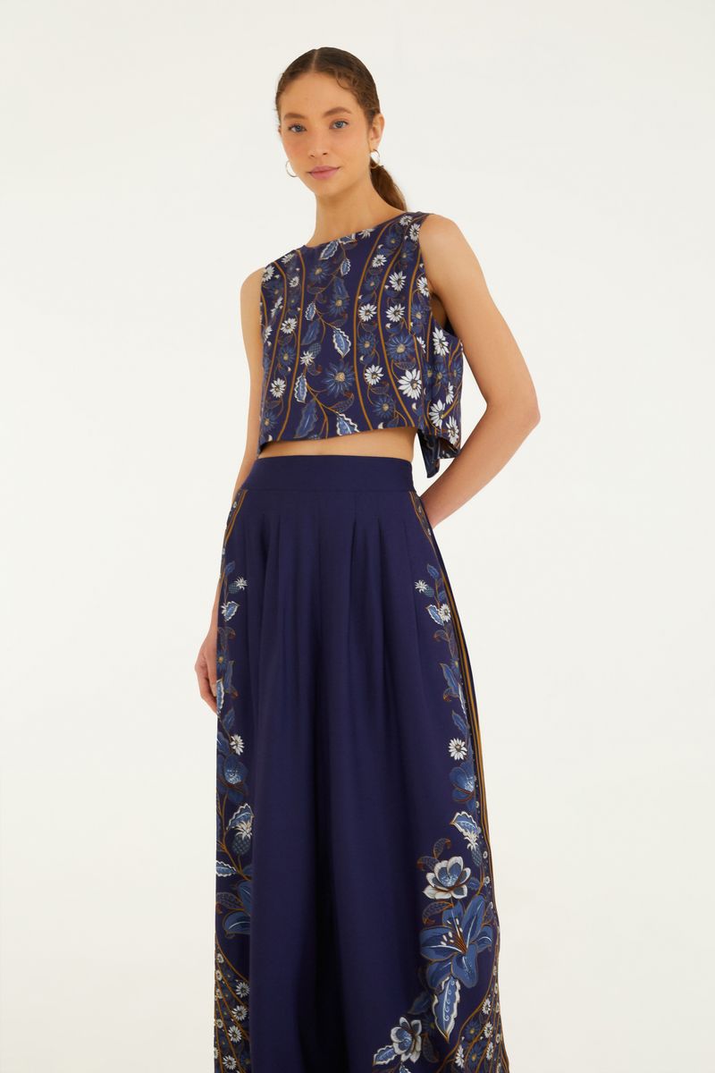 Imagen de un pantalón palazzo azul oscuro con estampado floral, visto por detrás.