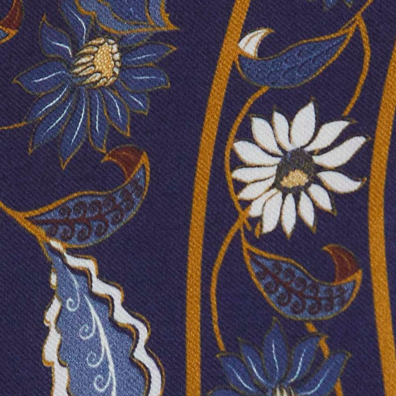 Detalle del estampado floral de la Regata Cropped Marcelle sobre fondo azul oscuro.