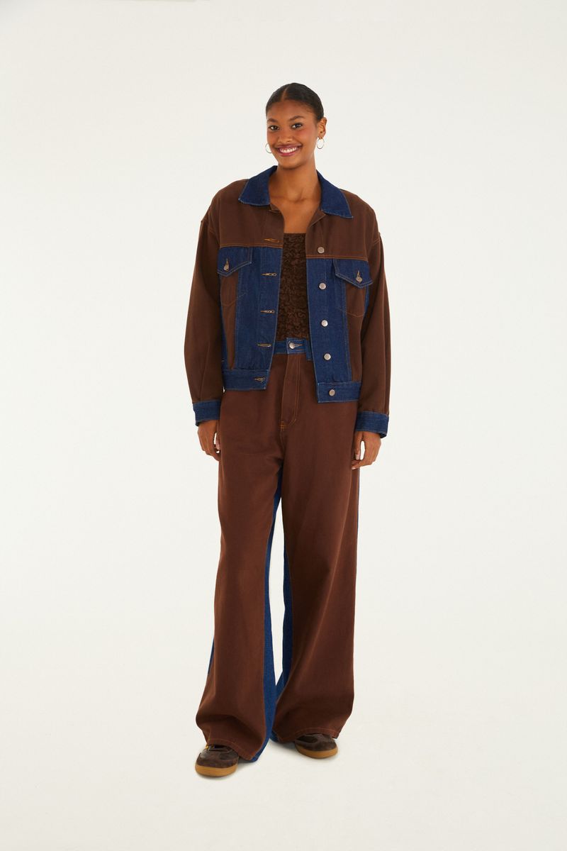 Modelo usando pantalón vaquero doble marrón con cintura aleta y chaqueta a juego.