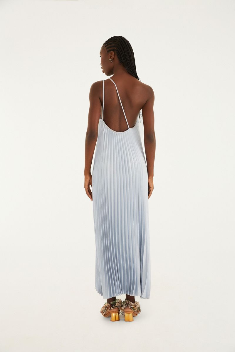 Imagen de un vestido largo plisado azul claro con tirante único, visto desde atrás.