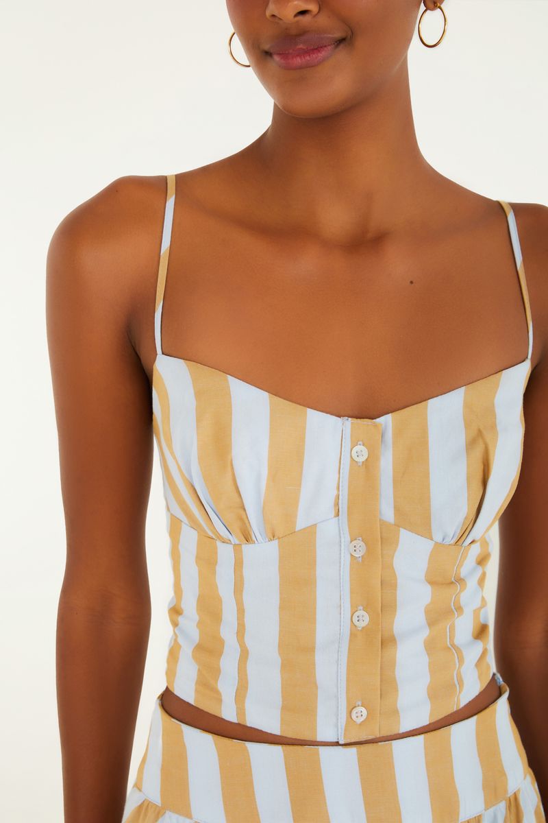 Detalle del escote en V y cierre con botones de la blusa de rayas bicolores.