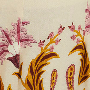 Detalle del estampado tropical tapicería en la falda del vestido largo con tirantas finas.