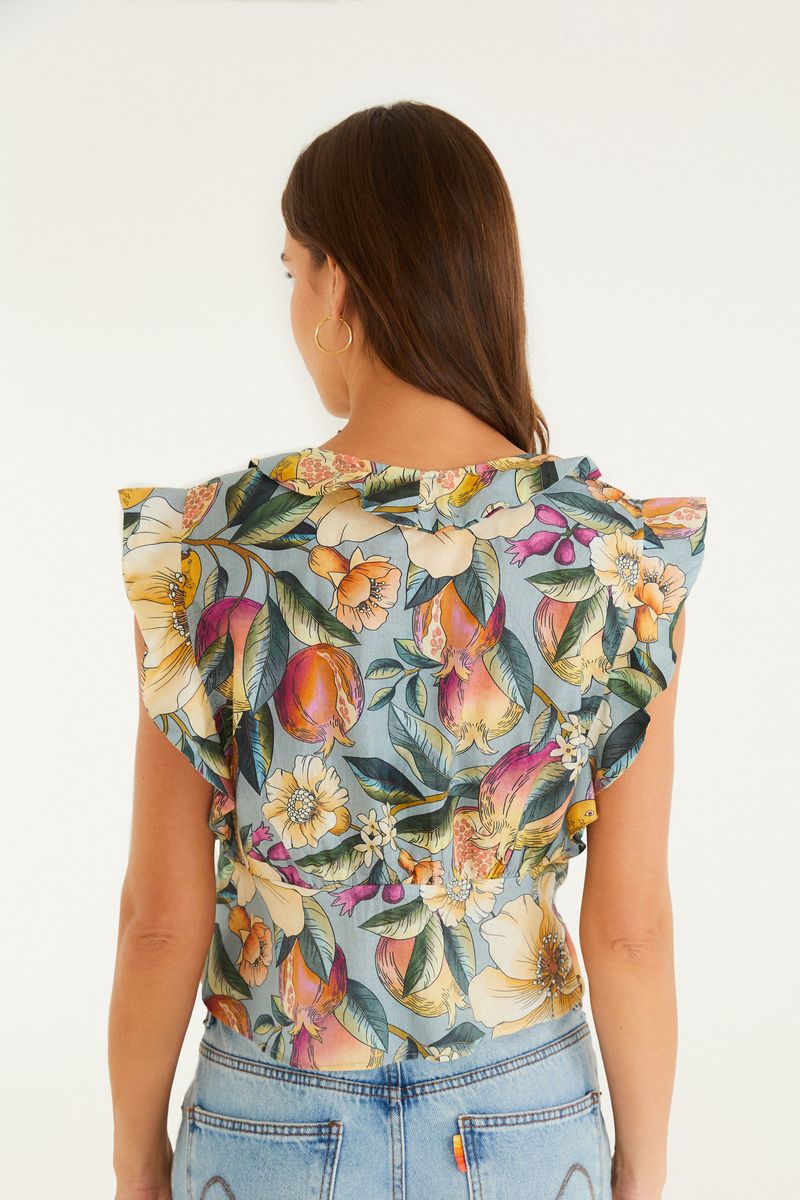 Vista trasera de la blusa mostrando la estampado floral y el diseño sin mangas.