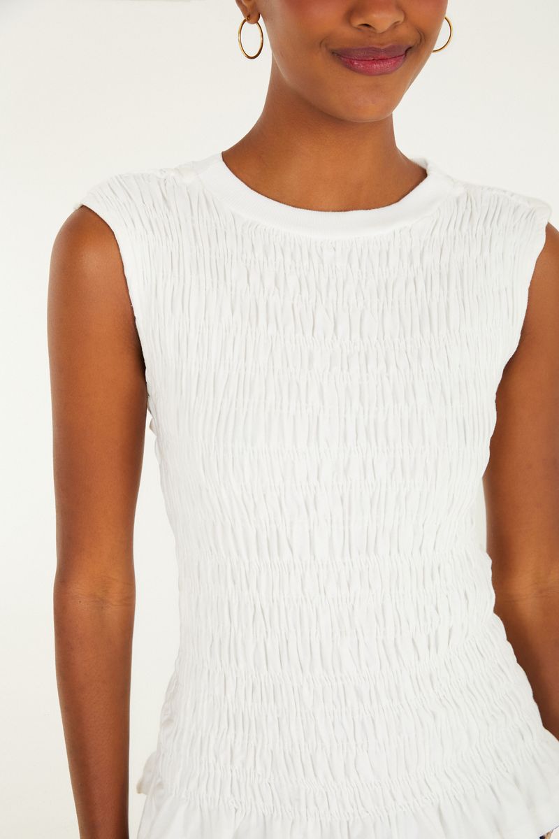Detalle de la textura lastex de la blusa blanca.