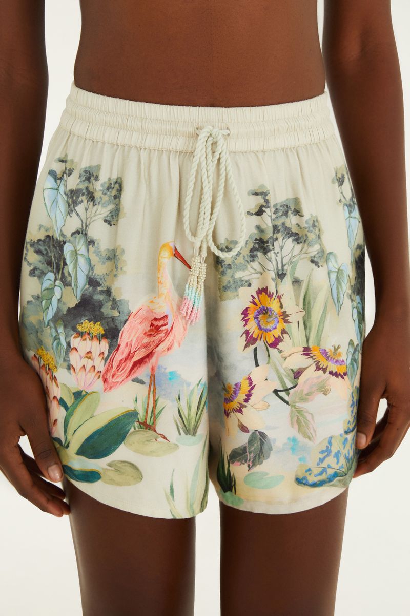 Close-up del short estampado con detalles de tucán y follaje.