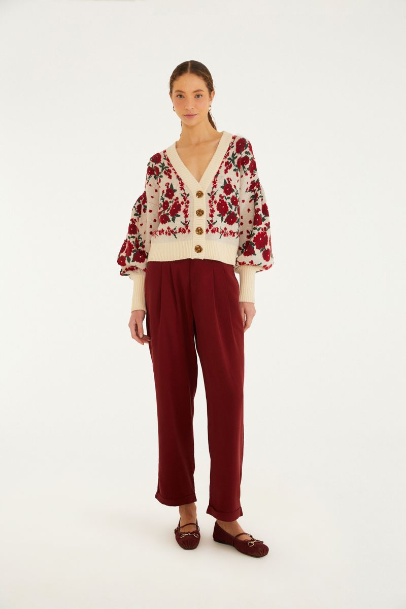 Modelo vistiendo pantalón zanahoria de sastrería rojo con blusa floral