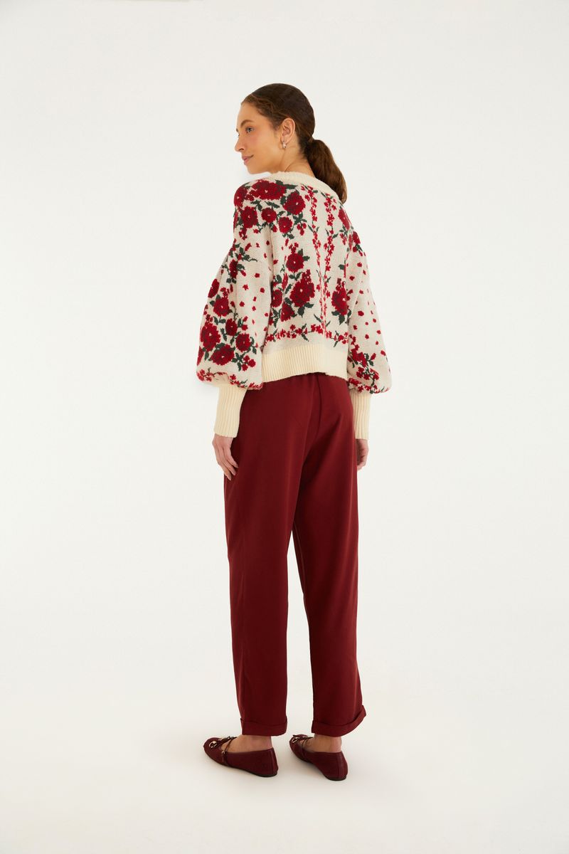 Modelo de espaldas vistiendo pantalón zanahoria rojo con blusa floral