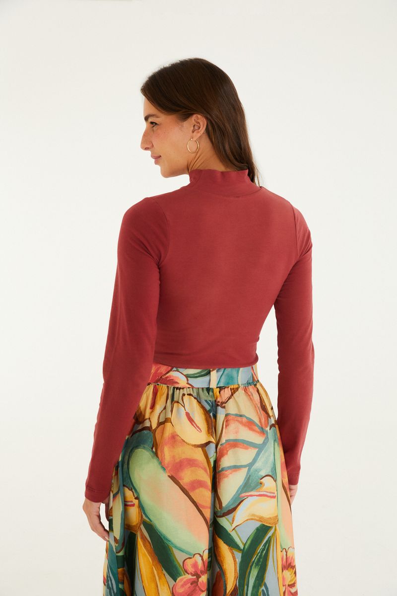 Blusa cropped cuello alto en tono sólido vista de espaldas.