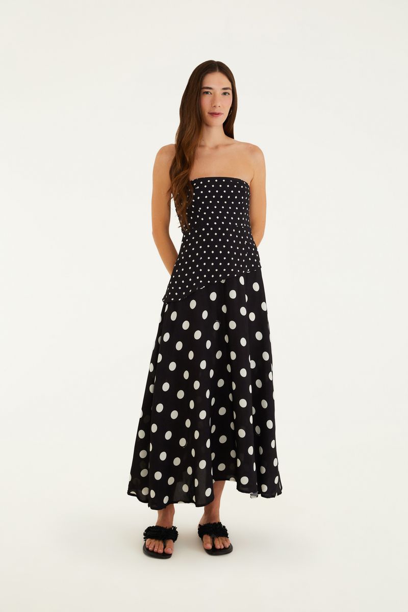 Vestido negro con estampado de puntos blancos, modelo sin mangas, largo midi, mostrado en pose frontal.