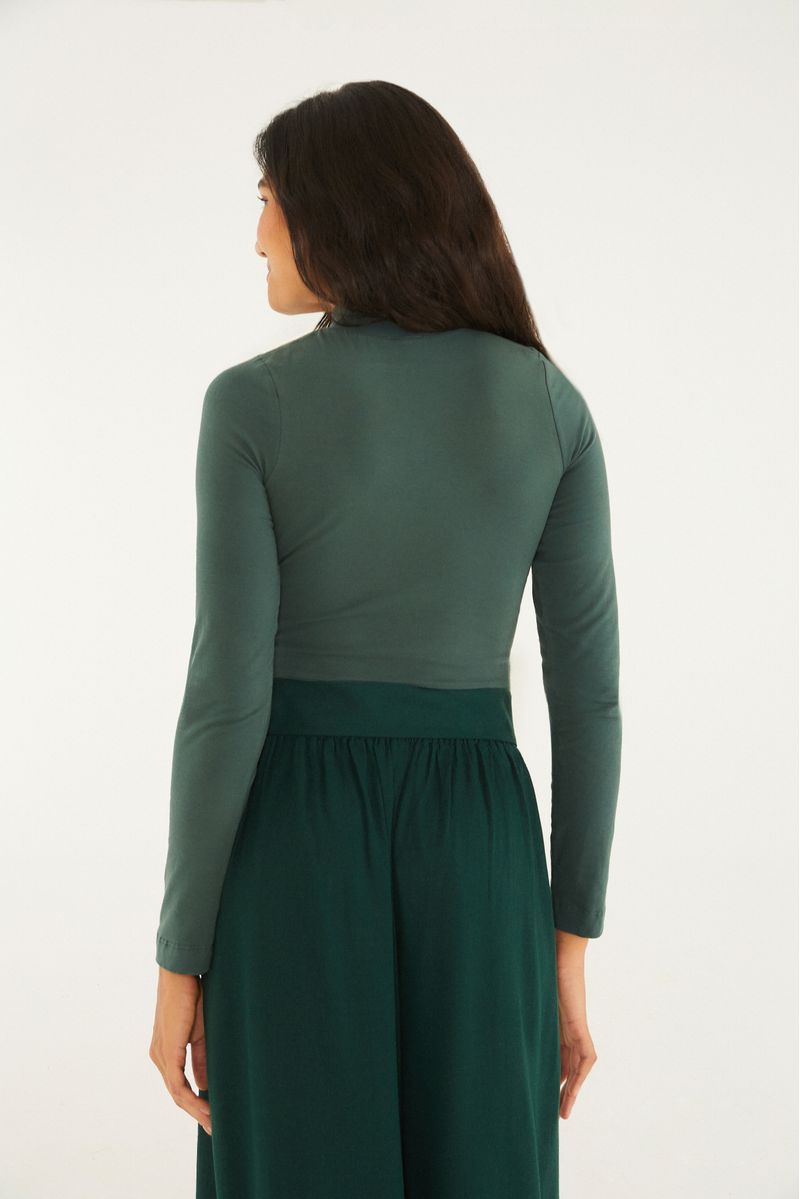 Detalle del cuello alto y manga larga de la blusa cropped verde.