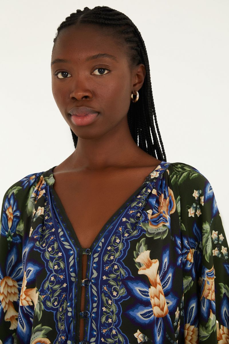 Detalle del escote en V y estampado floral de la blusa.