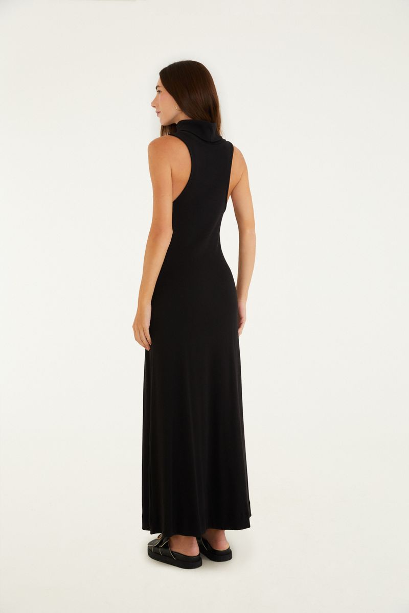 Vestido negro largo con cuello alto, visto de perfil.