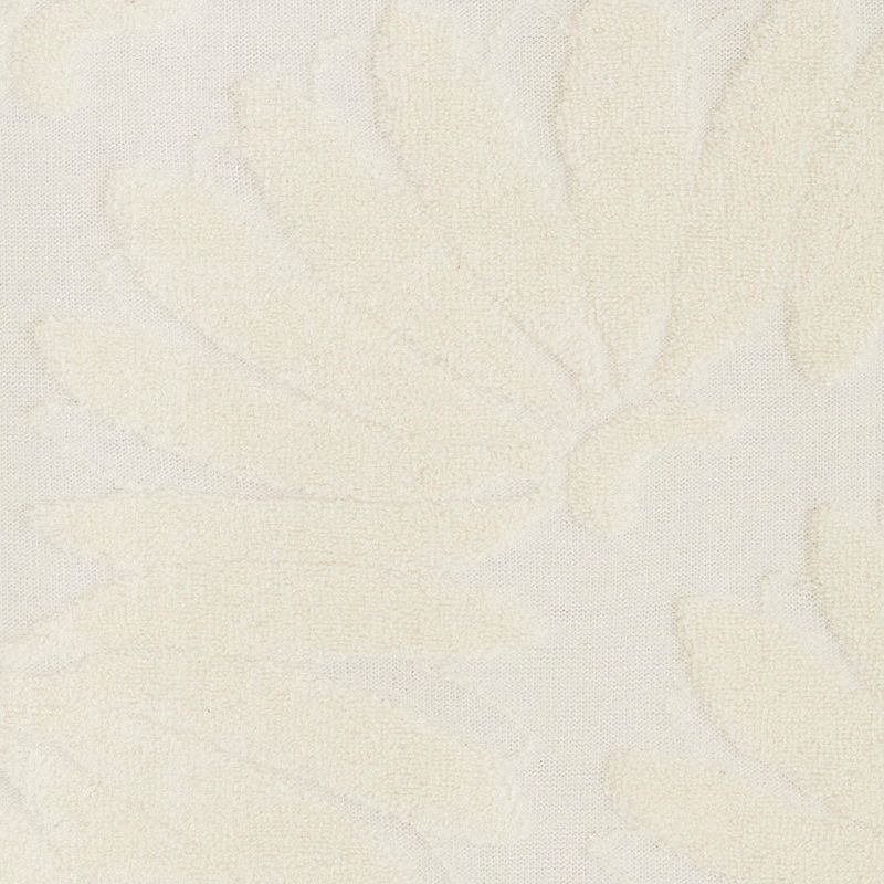 Detalle del tejido lurex del vestido corto mostrando textura y patrón.