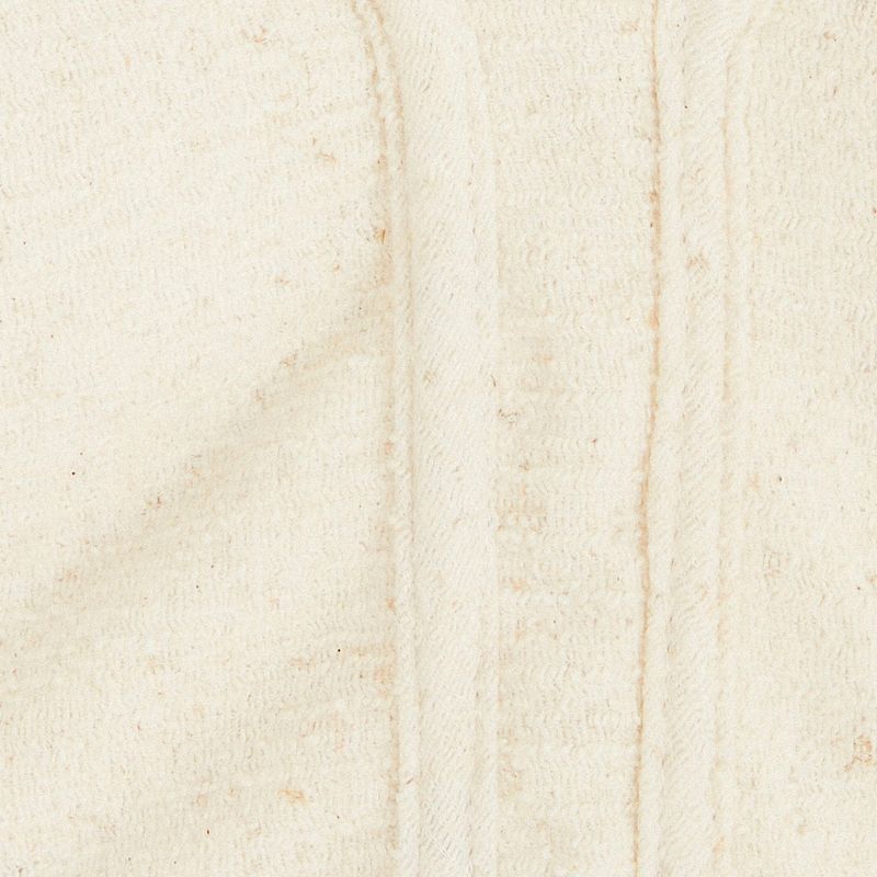Close-up del escote asimétrico de la Blusa Decote Asimétrico Tweed, destacando el diseño único.