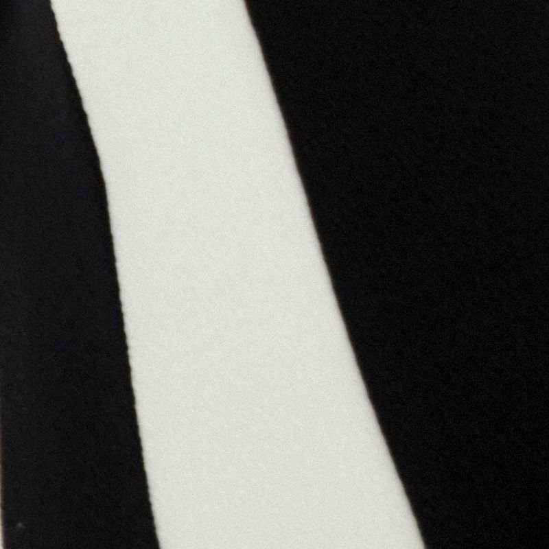 Detalle del borde del vestido con estampado geométrico en negro y blanco.
