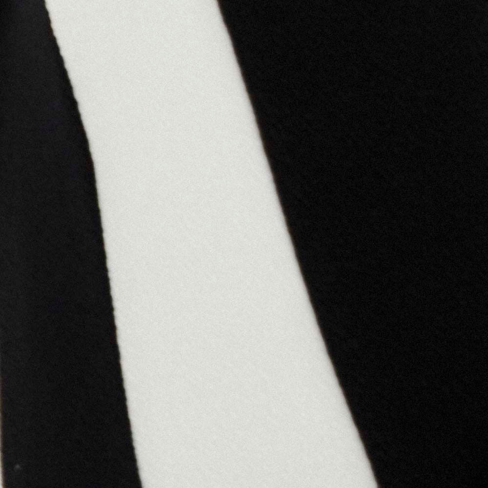 Detalle del borde del vestido con estampado geométrico en negro y blanco.