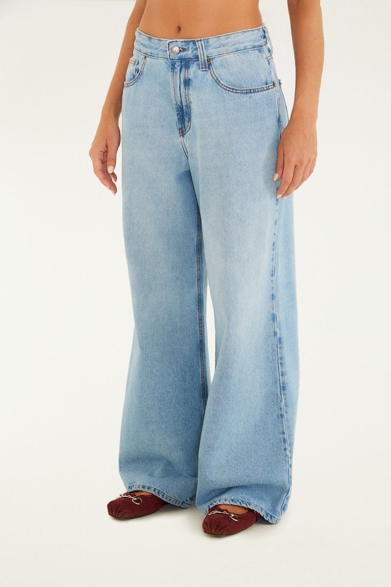Vista lateral del pantalón jeans maxi wide azul claro destacando el corte amplio.