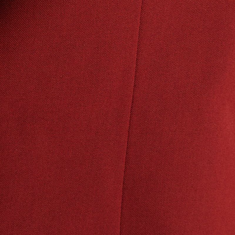 Acercamiento al bolsillo parche del blazer rojo de corte sastre.