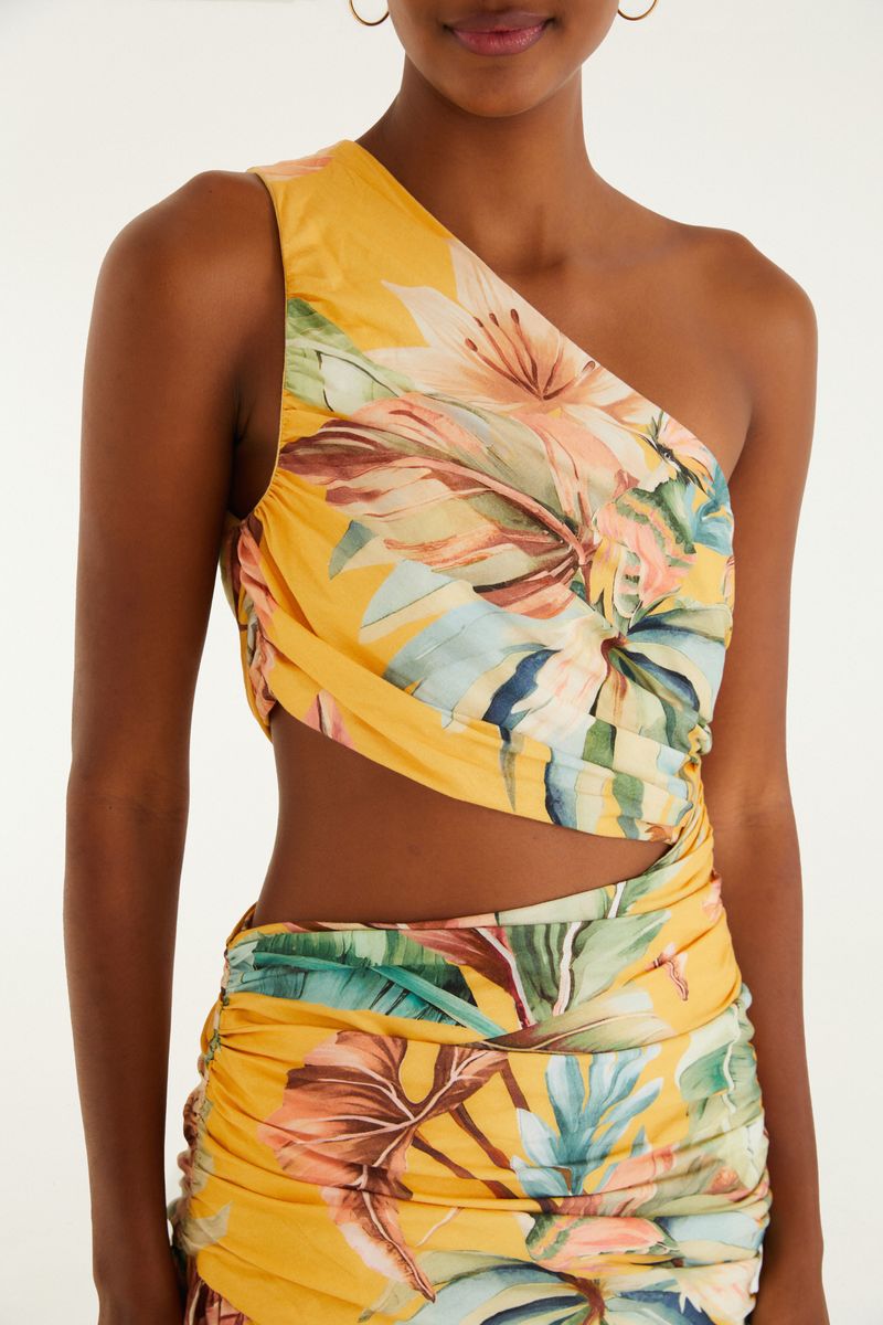 Detalle del escote y diseño tropical del vestido largo de un solo hombro.