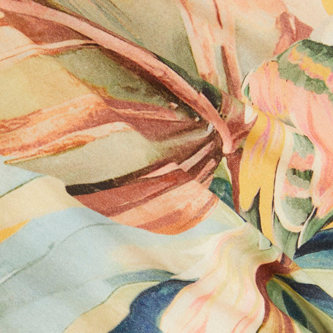 Primer plano del diseño tropical del vestido largo, mostrando detalles de colores y patrones.