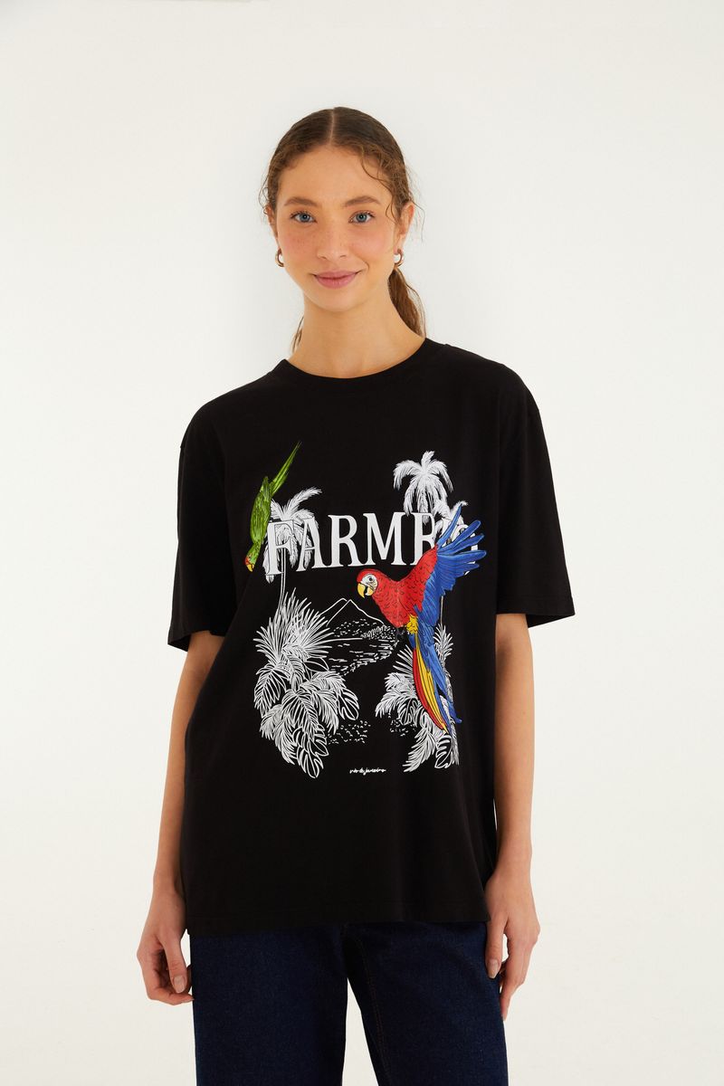 Vista frontal de camiseta negra con estampado tropical de guacamayas y follajes.