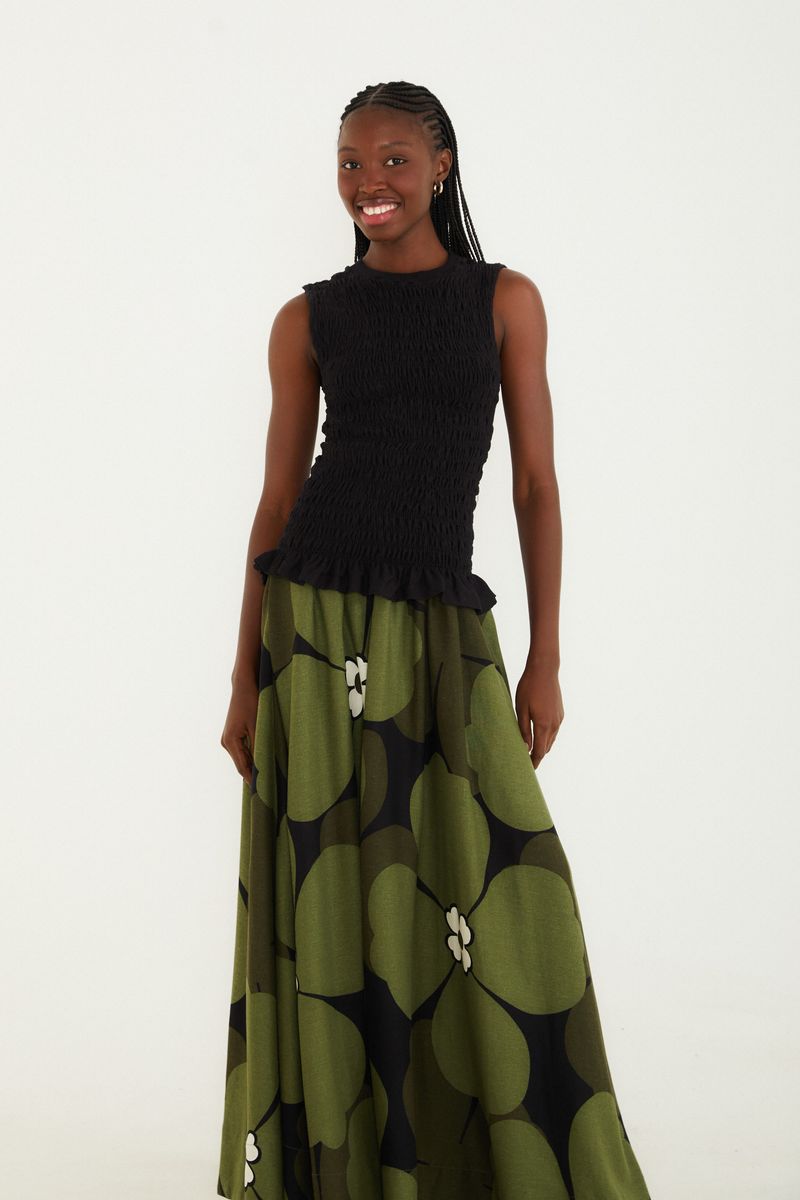 Imagen de una modelo luciendo la Falda Flor Bela, mostrando el diseño largo y fluido con estampado floral en tonos de verde y negro.