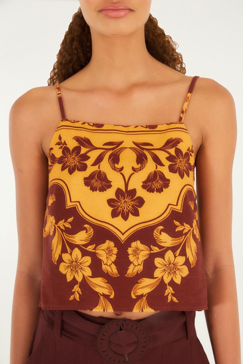 Imagen de una camiseta sin mangas floral con tirantes finos, detalle del estampado floral en tonos amarillos y marrones.