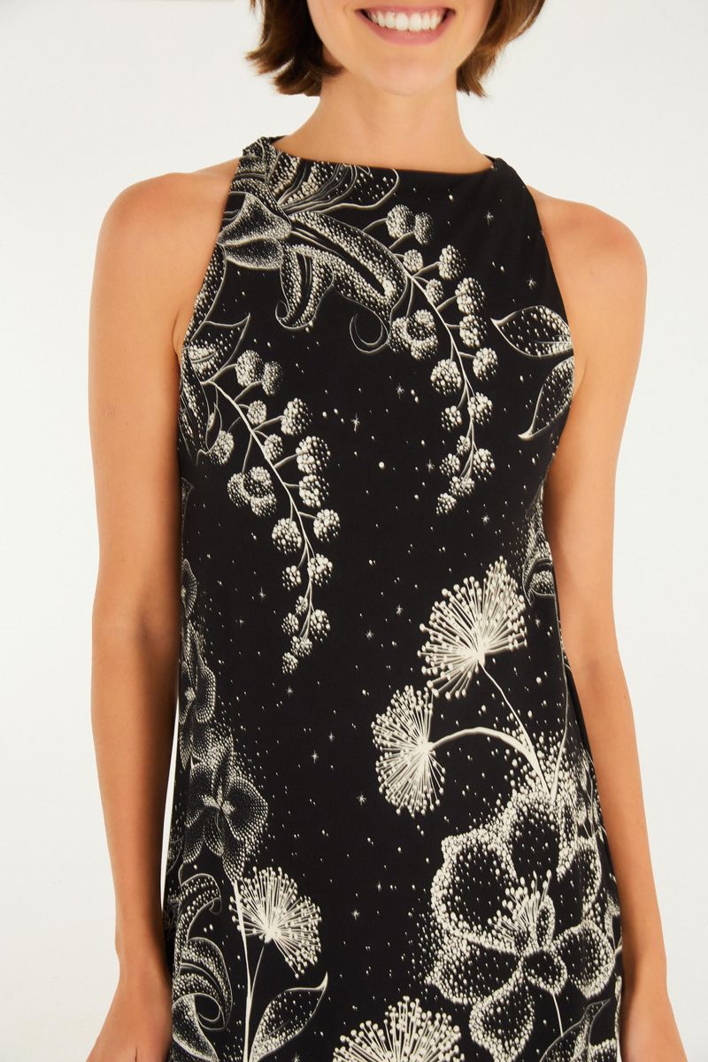 Detalles del escote del vestido corto negro con estampado floral blanco.