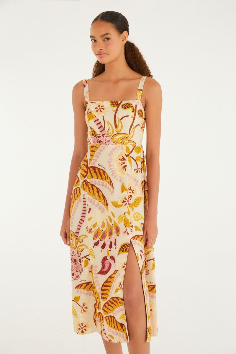 Imagen de un vestido corto con estampado tropical, tirantes delgados y escote cuadrado, visto de lado.