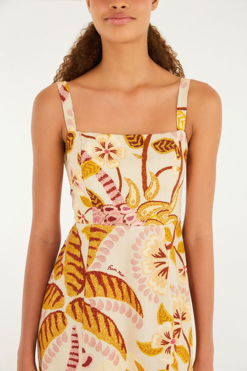 Imagen de un vestido corto con estampado tropical, tirantes delgados y escote cuadrado, mostrando detalles del corpiño.