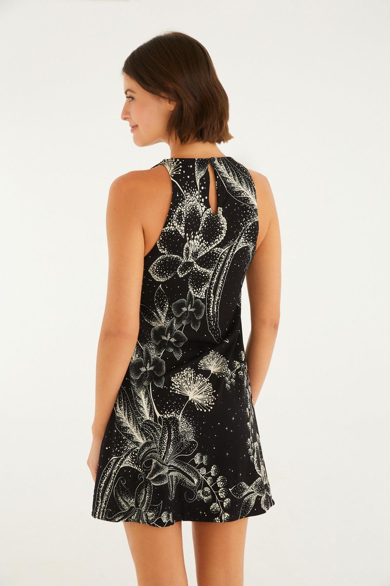 Vista lateral del vestido corto negro con estampado floral blanco.