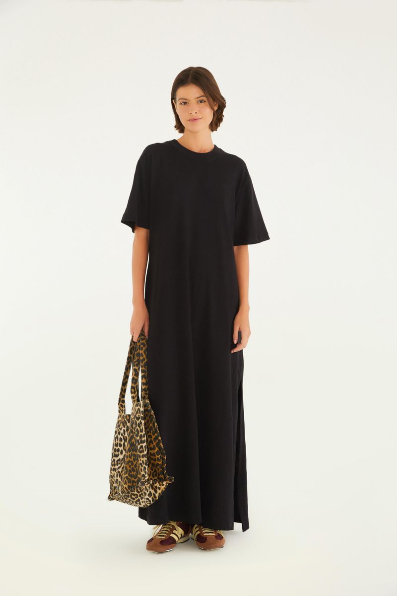 Vestido negro estilo camiseta con abertura lateral, exhibido en una pose frontal completa.