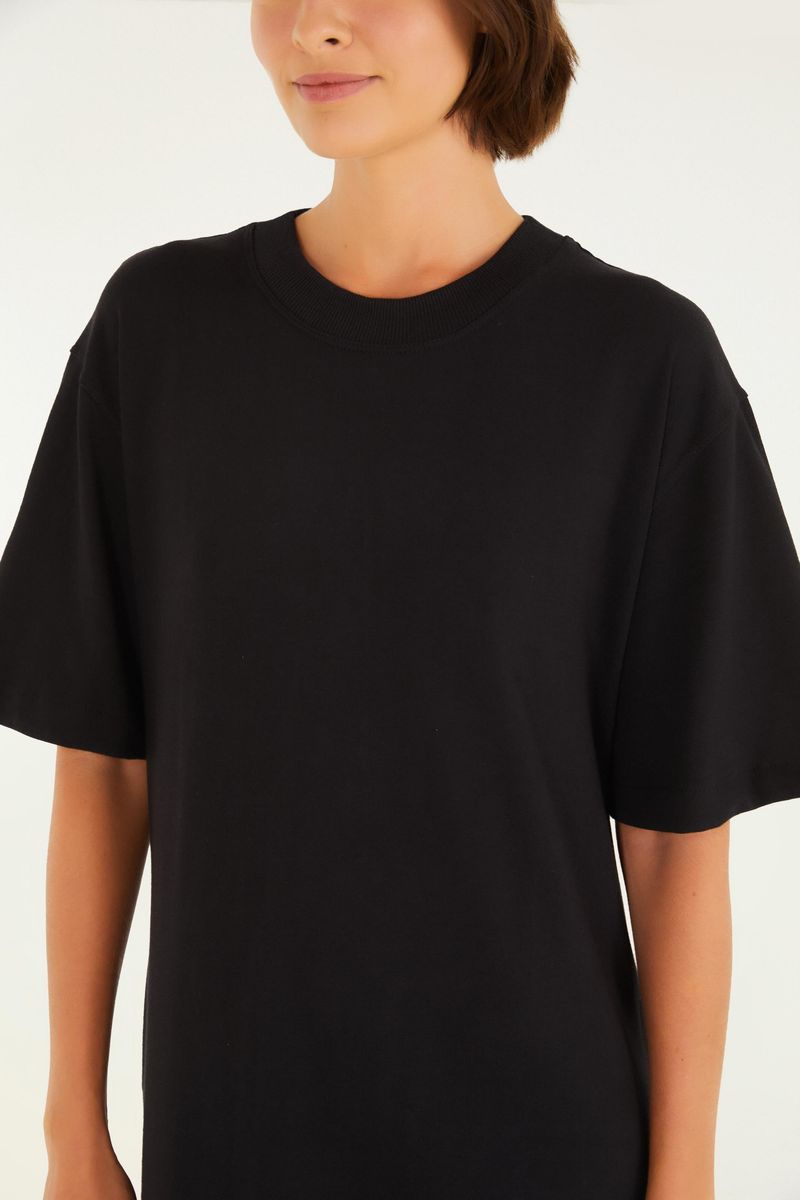 Detalle del cuello redondo del vestido negro estilo camiseta.