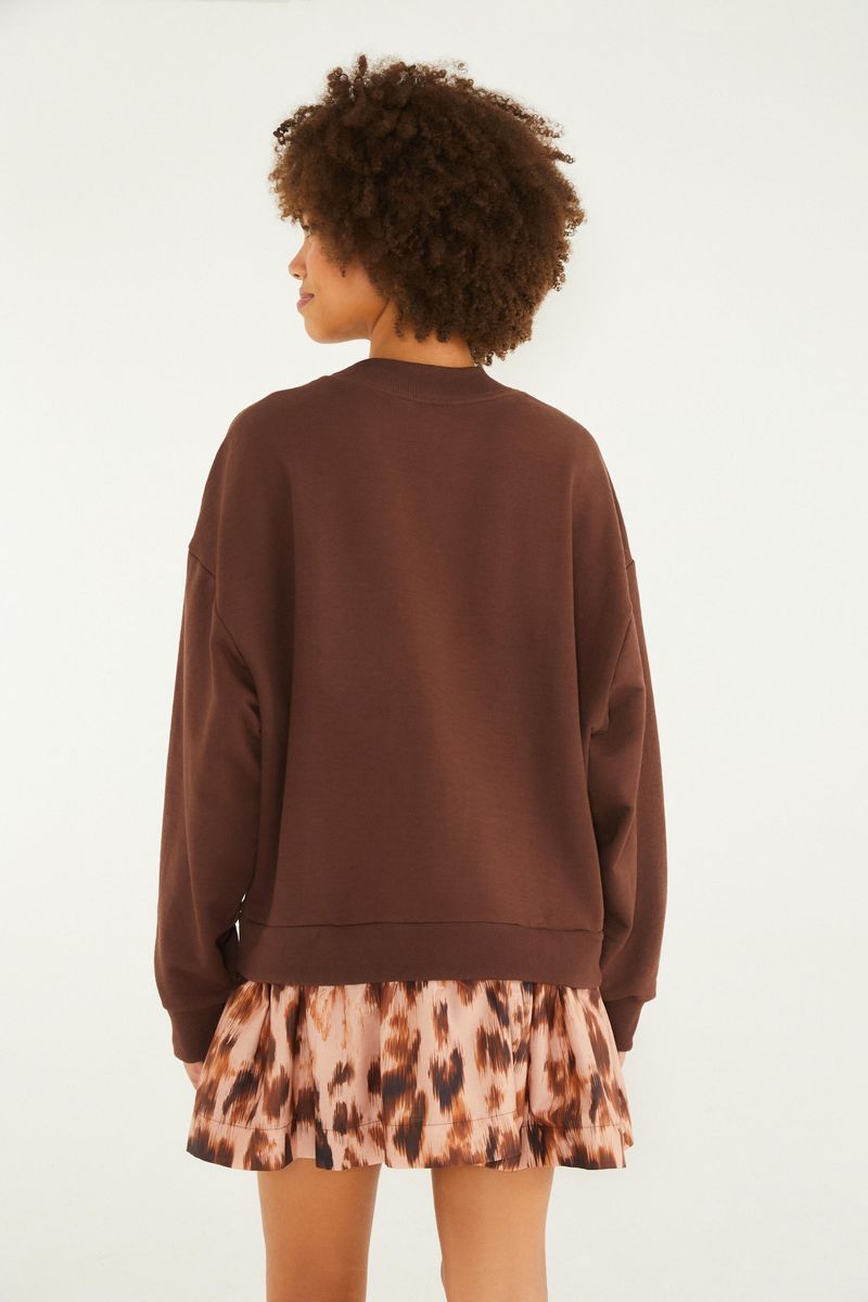 Vista trasera del vestido de moletón marrón con estampado de tigre y texto 'Farm Rio', mostrando detalles de la falda estampada.