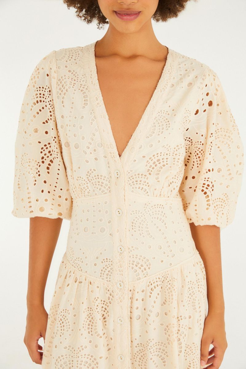 Imagen de un vestido largo beige con detalles de laise, exhibido de espaldas.