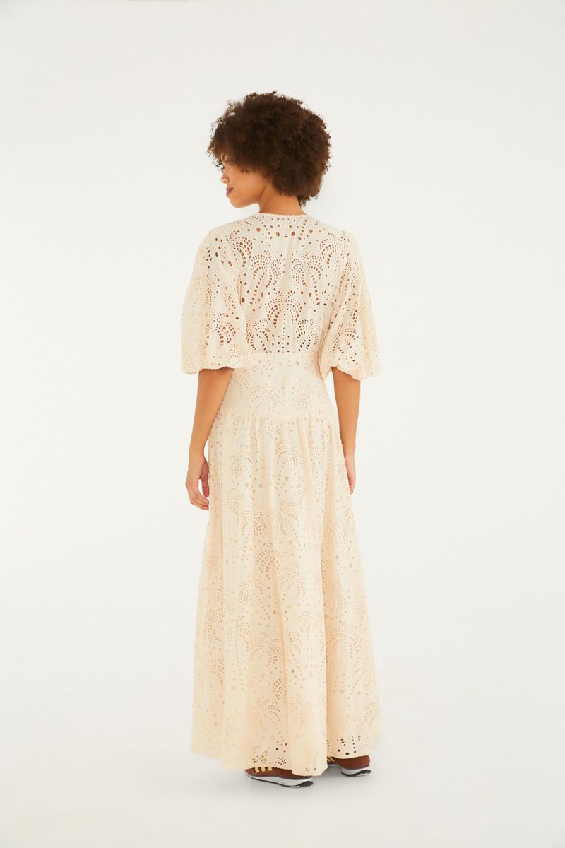 Imagen de un vestido largo beige con detalles de laise, mostrando el escote frontal.