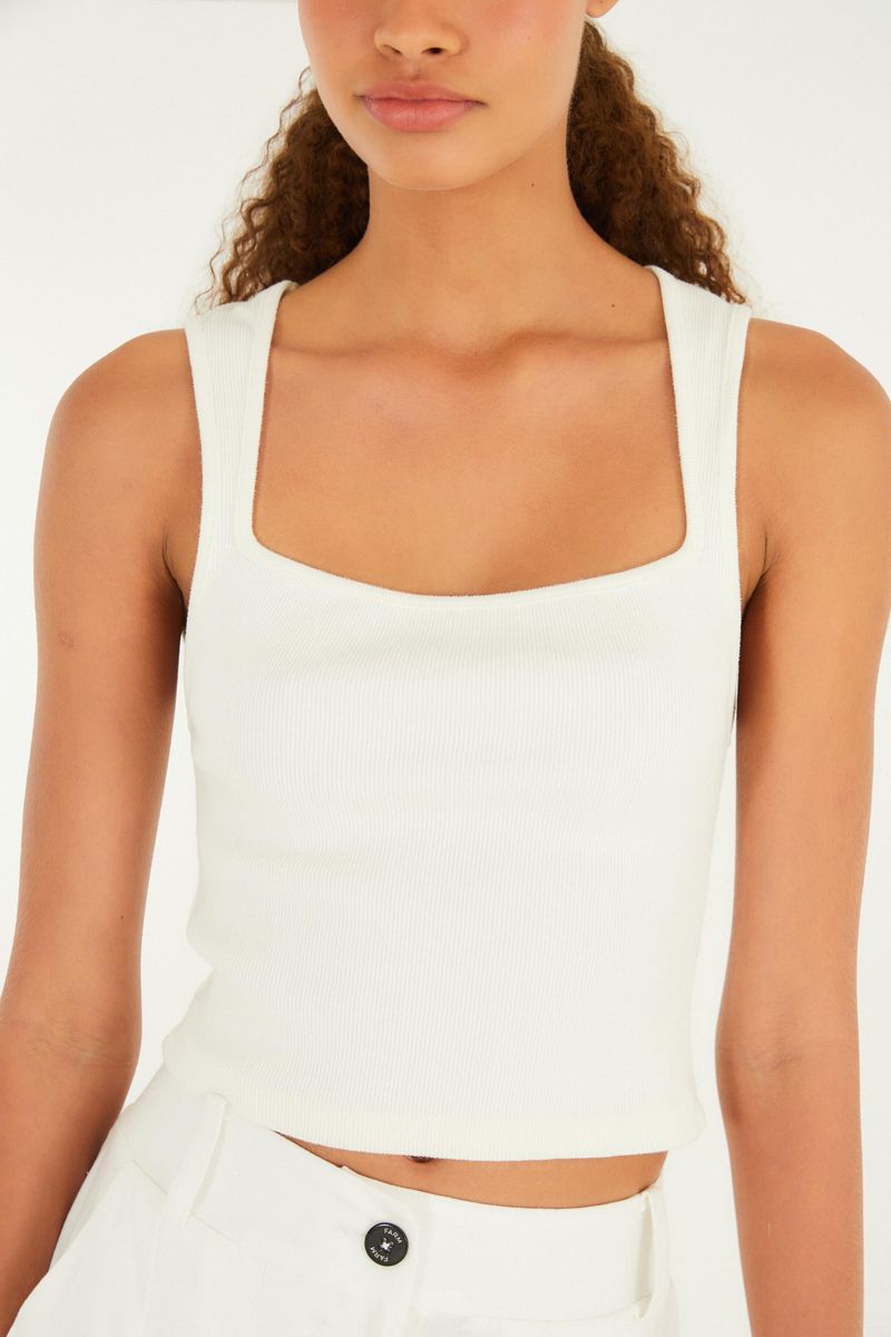 Imagen de close-up de la camiseta de tirantes estilo cropped blanca, evidenciando el tejido y el escote.