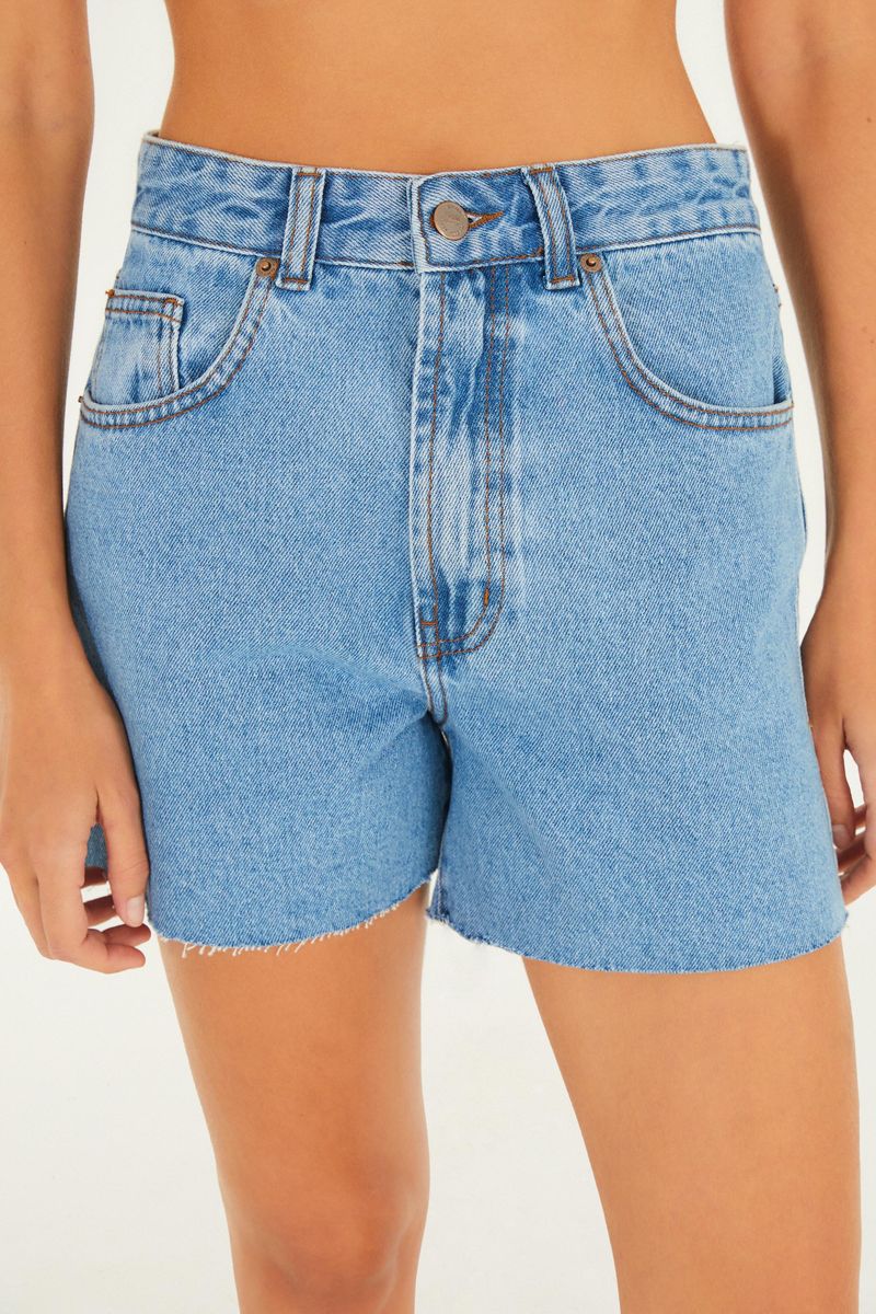 Primer plano del frente del short jean azul con detalles de bolsillos y botón.