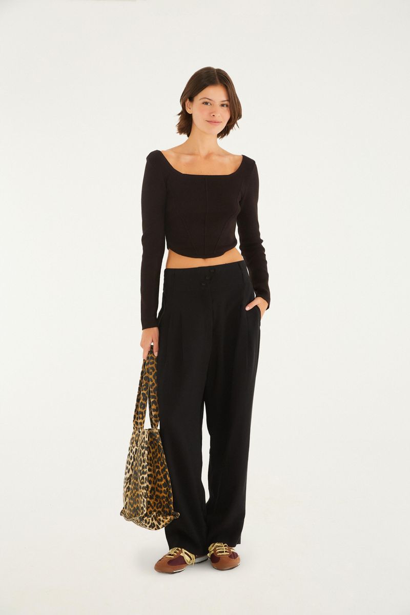 Modelo usando el top negro con pantalón negro y bolso con estampado de leopardo.